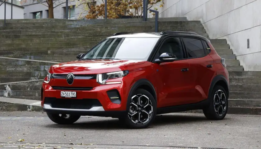 Czerwony Citroen EC3 z czarnym dachem stoi na tle betonowych schodów.