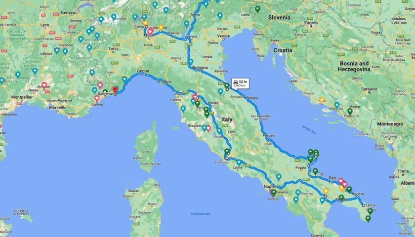 A winding blue line traces a scenic Italy road trip route from the French border, through the Alps, down the Italian peninsula, and across to Sicily.