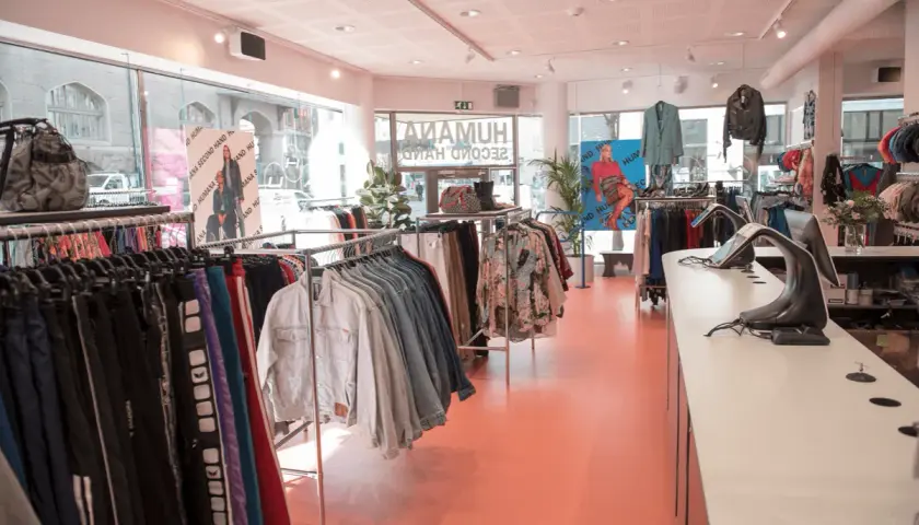 En ljus second hand-butik med kläder på galgar och skyltdockor. Kanske hittar du dina nästa humana second hand lediga jobb här!