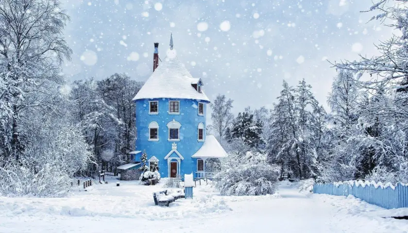 Niebieski domek w śnieżnym lesie, jak z bajki. To prawdziwy winter wonderland tekst, otoczony drzewami pokrytymi białym puchem.