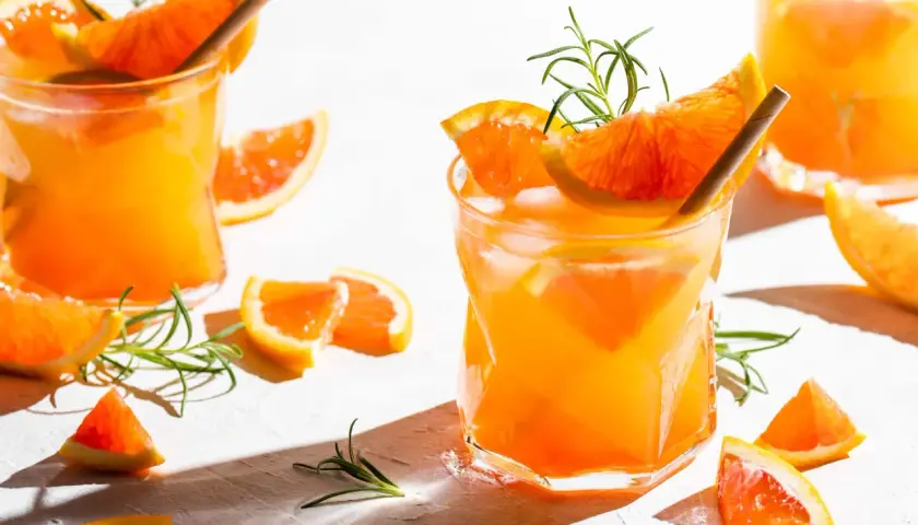 Erfrischender Aperitif mit Prosecco, Orangenstücken und Rosmarin. Perfekt für einen sonnigen Nachmittag.