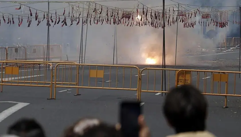 El estruendo de la mascletà hoy llena el aire de humo y chispas. Cuerdas de petardos cuelgan, esperando el momento de explotar.