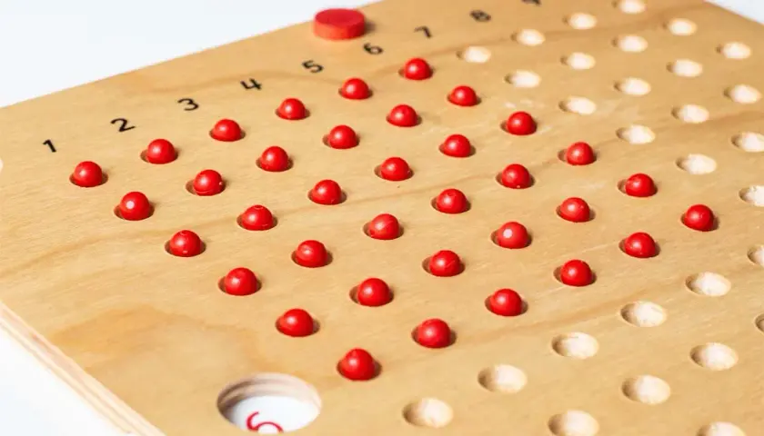 Holzbrett mit roten Kugeln und Zahlen von 1-10. Ideal für 1x1 spielerisch lernen kostenlos.