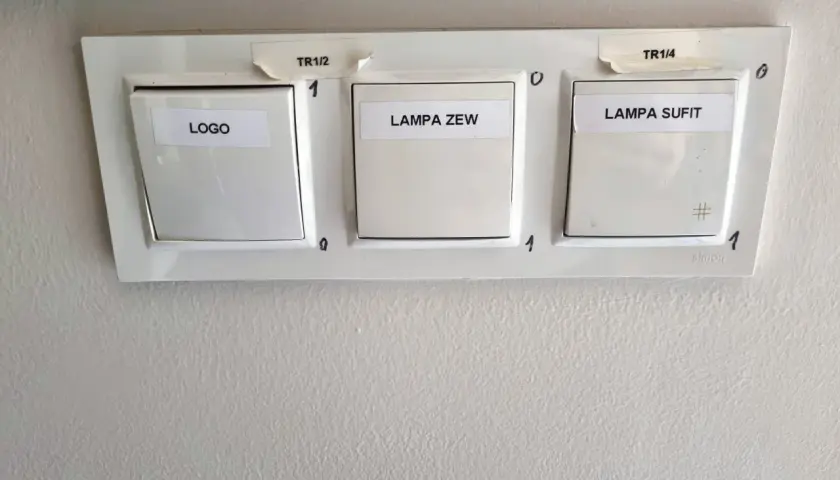 Trzy włączniki światła: LOGO, LAMPA ZEW, LAMPA SUFIT. Na górze oznaczenia TR1/2 i TR1/4. Włączniki to proste przełączniki on/off.