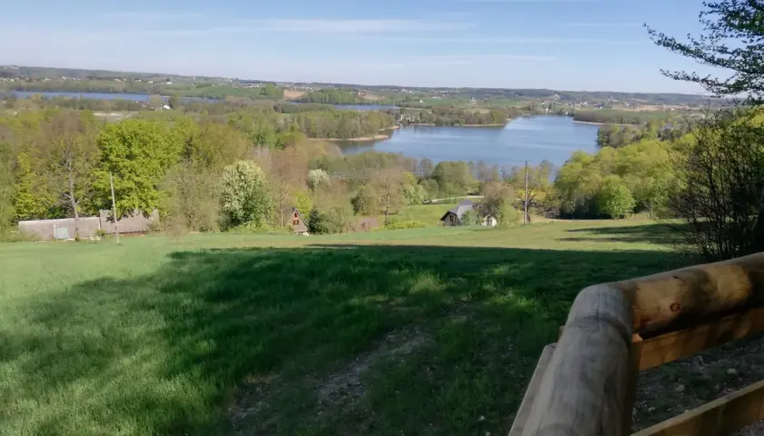 Widok z tamtej góry na jezioro i zielone wzgórza.