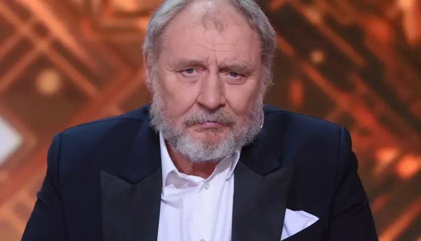 Andrzej Grabowski, znany z roli Ferdynanda Kiepskiego, w eleganckim garniturze. Jego wiek dodaje mu powagi.