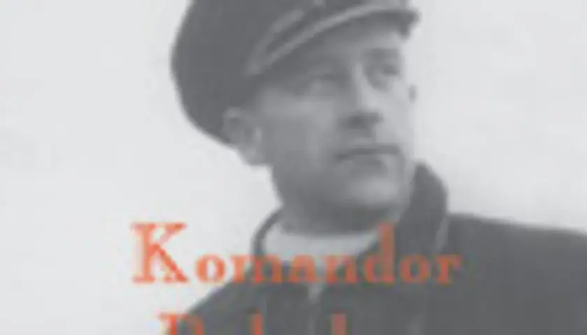 Portret mężczyzny w czapce, z napisem "Komandor". Jaki to stopień? To pytanie zadaje obraz, przedstawiając postać w wojskowym nakryciu głowy.