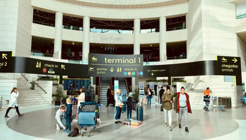 Menschen mit Gepäck im Terminal 1 des Lissabon Flughafens, bereit für die Weiterreise in die Stadt.