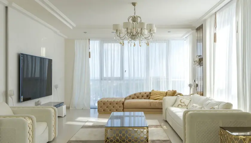 Elegancki salon z białymi sofami i złotymi akcentami. Czy można łączyć srebro ze złotem w domu? Tak, tworząc luksusową przestrzeń.