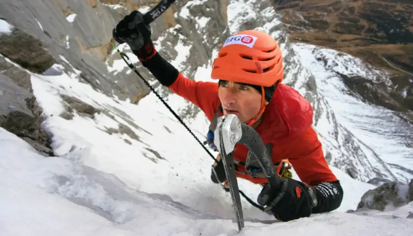 Ueli Steck klettert mit Steigeisen und Eispickel einen eisigen Berghang hinauf.