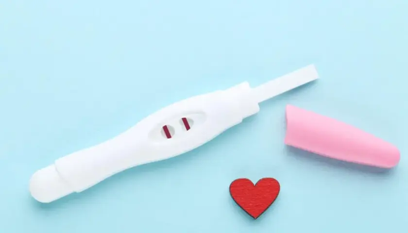 Test ciążowy z dwoma czerwonymi kreskami, różowa nakładka i serduszko. Kiedy zrobić test ciążowy?