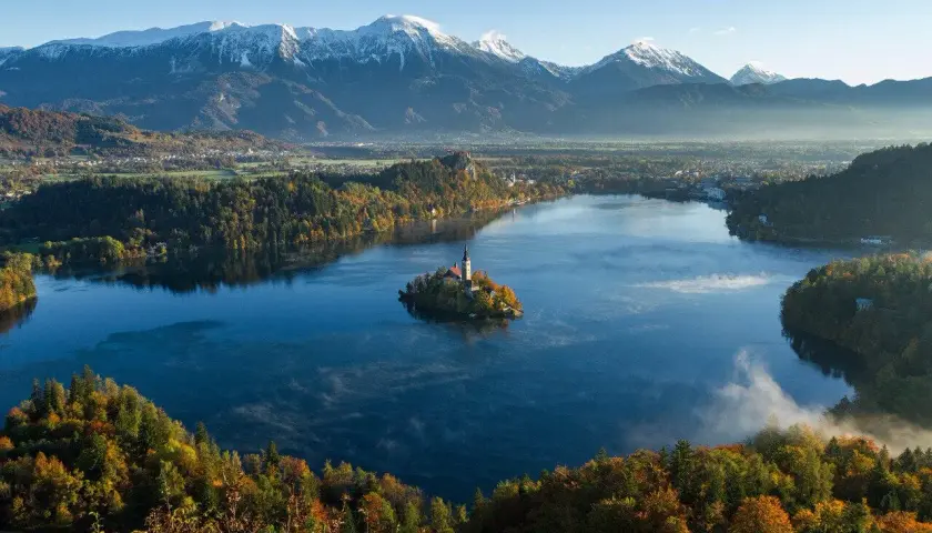 Jezioro Bled ze swoją malowniczą wyspą i kościołem to jedna z najpiękniejszych słowenia atrakcje. W tle majestatyczne Alpy.
