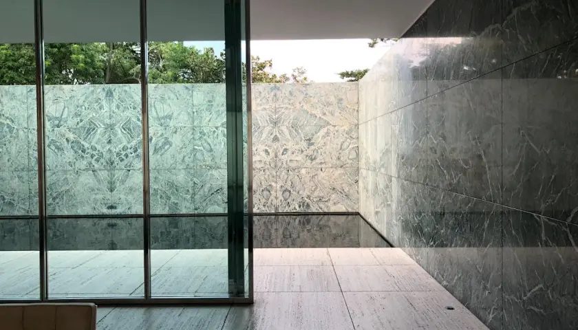 Pavimenti in travertino pro e contro: un'elegante terrazza con pareti in marmo verde e un piccolo specchio d'acqua.