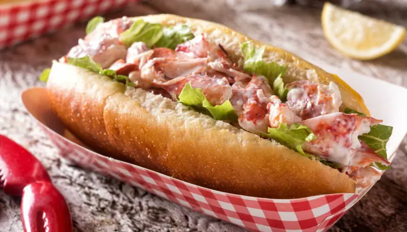 Un généreux hummer sandwich, garni de homard frais et de laitue croquante, servi dans un pain brioché.