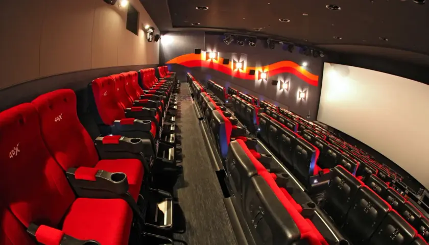 Puste czerwone fotele kinowe z logo 4DX czekają na widzów.