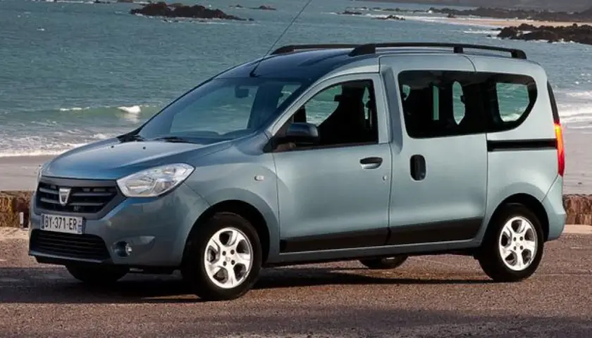 Auto blu con porte scorrevoli parcheggiata sulla costa. Ideale per avventure familiari al mare.