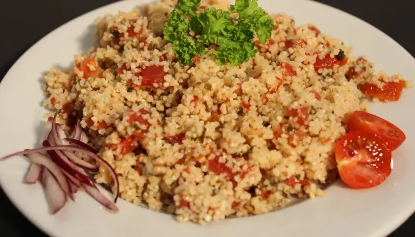 Taboulé traiteur frais, garni de persil et tomates. Le prix est très attractif pour cette spécialité méditerranéenne.