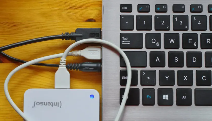 Externe Festplatte wird als USB-Laufwerk erkannt. Kabel verbinden die Festplatte mit dem Laptop.