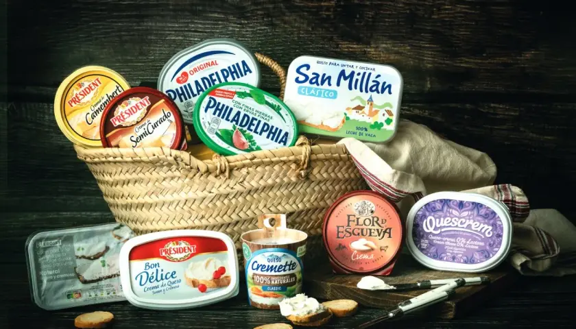 Variedad de quesos crema en cestas y recipientes, incluyendo marcas como Philadelphia y Président. Ideal para untar y disfrutar.