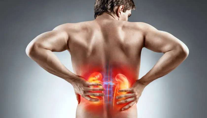 Hombre con dolor de riñones, sintiendo un dolor agudo que se irradia, como si fuera un dolor de regla intenso.
