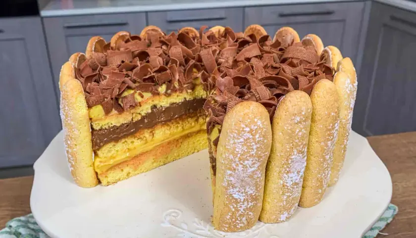 Una deliziosa zuppa inglese ricetta facile, con strati di pan di Spagna, crema pasticcera e cioccolato, decorata con savoiardi e riccioli di cioccolato.