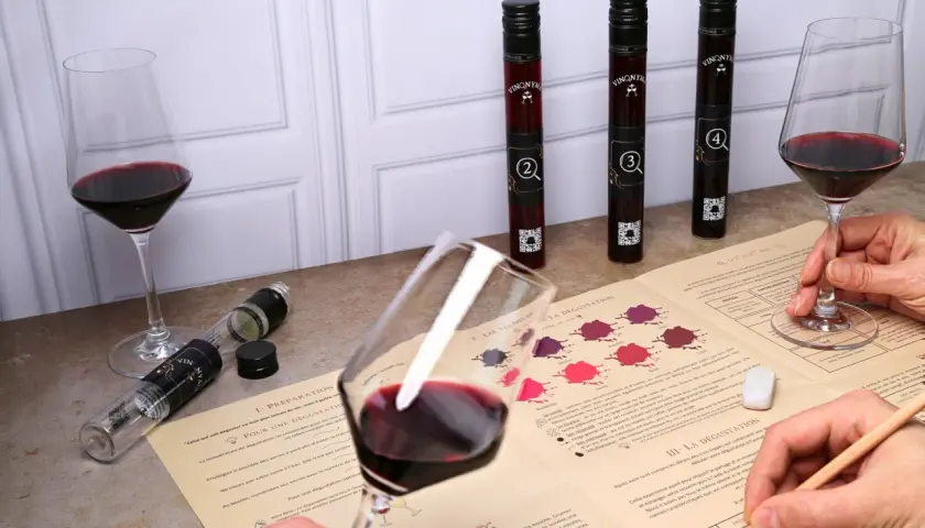 Dégustation vin Touraine : verres de vin rouge, fioles numérotées et guide d'analyse pour une expérience œnologique.