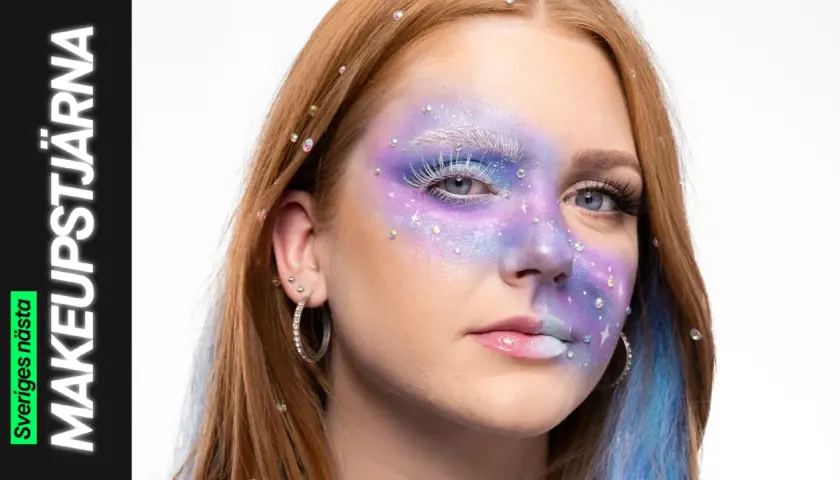 En ung kvinna med fantasifull sminkning i lila och blått, inspirerad av 60 tals smink. Glitter och stenar pryder ansiktet.