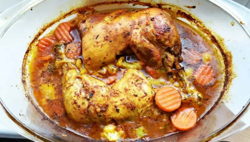 Pieczone udka z kurczaka w aromatycznej marynacie, z marchewką i brokułami, w szklanym naczyniu.