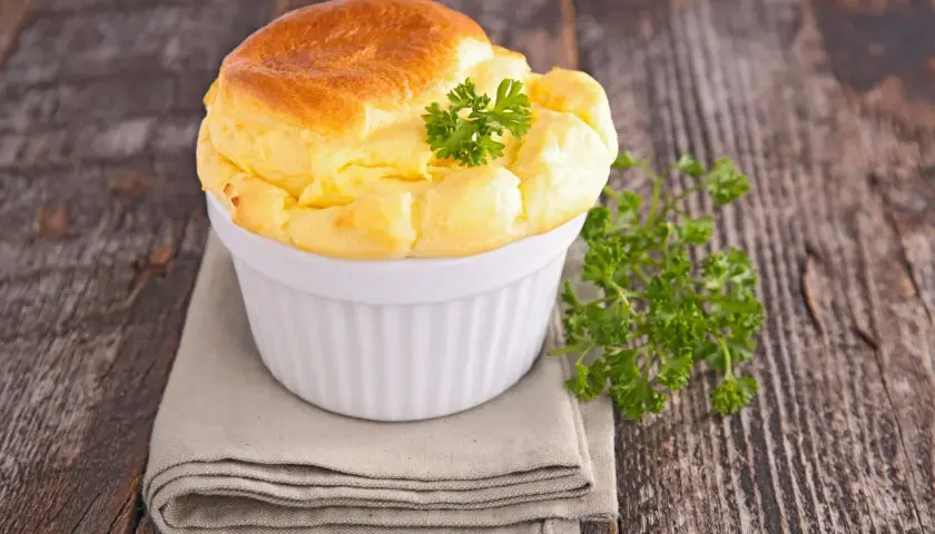 Un soufflé salé doré et aérien, garni de persil frais, parfait pour une recette de soufflé salé facile.