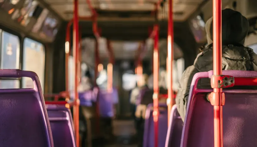 Wnętrze autobusu relacji Sanok-Wetlina. Fioletowe siedzenia i czerwone poręcze tworzą charakterystyczny widok.