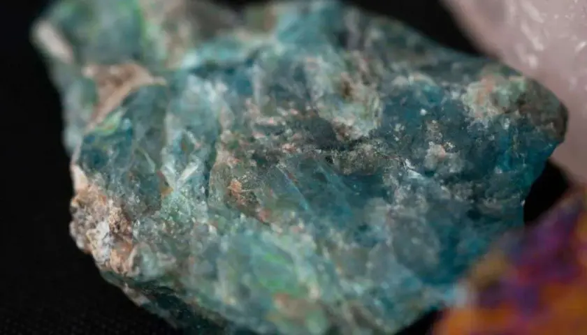 Un trozo de mineral azul verdoso, que evoca el topacio azul significado de calma y sabiduría.