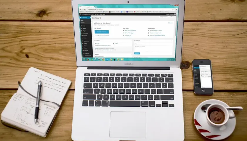 Na laptopie widać panel WordPress, obok smartfon i notatnik. To idealne miejsce do nauki, jak zainstalować WordPress na XAMPP.
