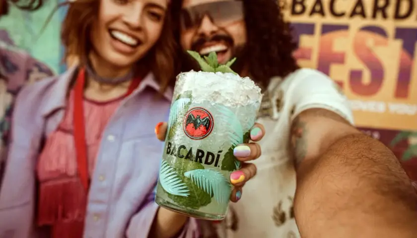 Radosna para świętuje na festiwalu z orzeźwiającym drinkiem Bacardi Mojito.