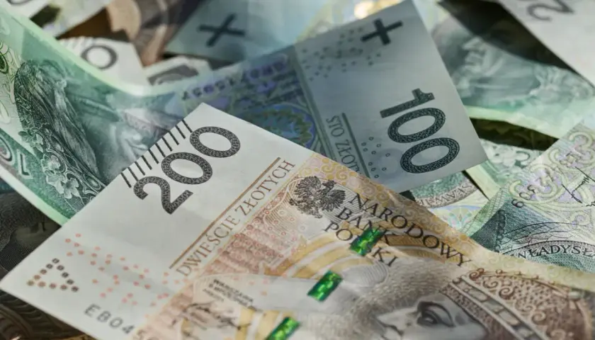 Stos banknotów 100 i 200 zł. Marzenie o trzynastce w 2026 roku nabiera kształtów.