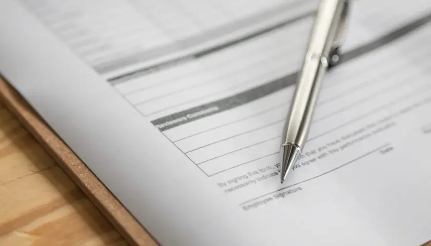 Srebrny długopis leży na dokumencie z polem "Employee Signature". To zap-3, gotowy do podpisu.