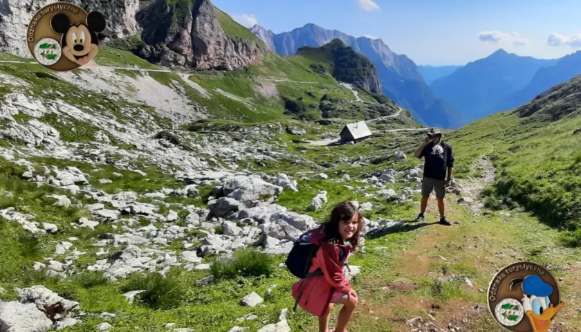 Dzieci i tata w górach, zdobywają kolejne punkty PTTK. Widok na dolinę i schronisko.