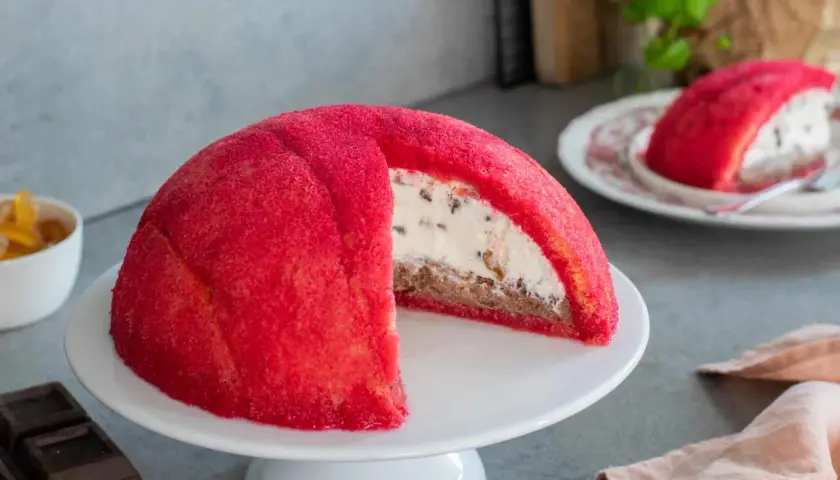 Un invitante zuccotto semifreddo, con la sua cupola rossa brillante e un cuore cremoso e goloso.
