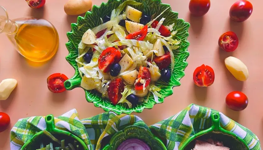 Deliziosa insalata di patate napoletana con pomodorini, olive e lattuga, condita con olio d'oliva.