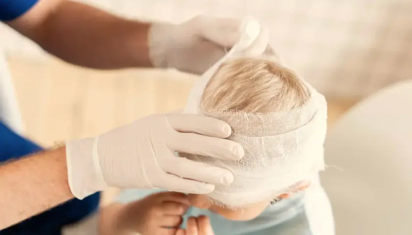 Un niño con la cabeza vendada. Si hay golpes en la cabeza de niños, cuándo preocuparse.