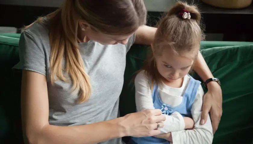 Madre intenta consolar a su hija, que se muestra enfadada y con los brazos cruzados. Un momento difícil cuando un hijo trata mal a su madre.