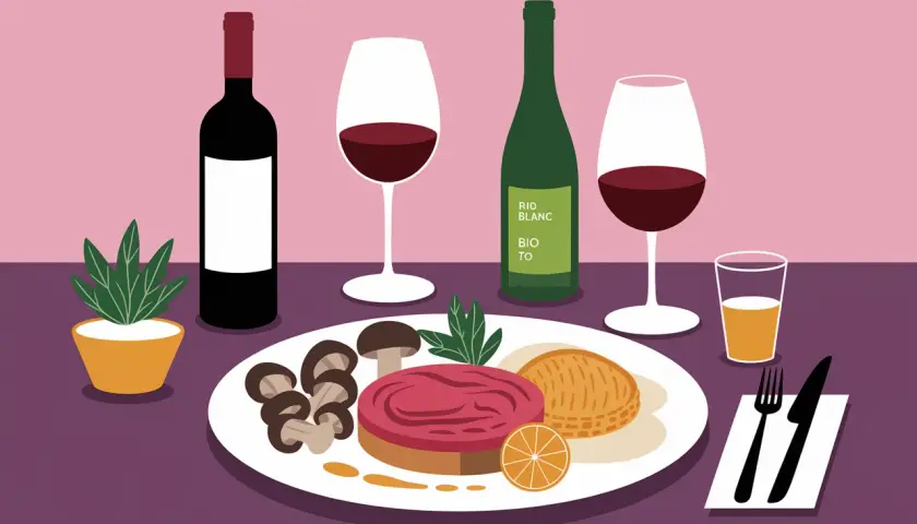 Un dîner élégant avec vin et pintade, accompagné de champignons, d'une tranche d'orange et d'une pâtisserie.