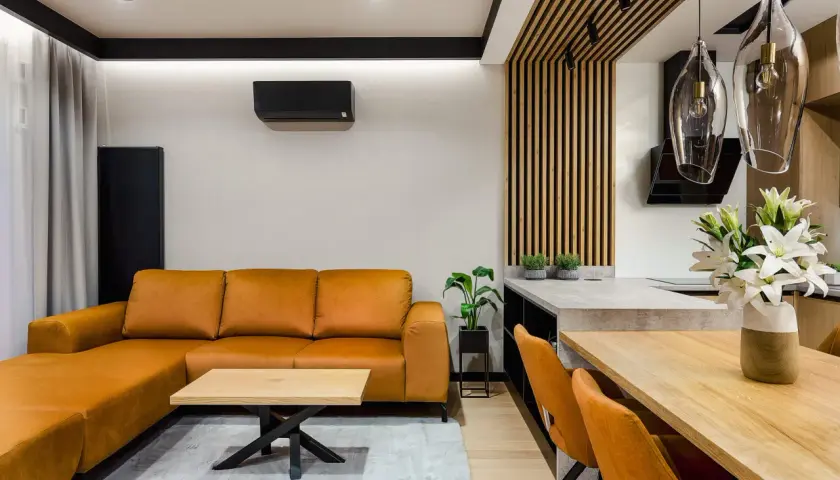 Pomarańczowa kanapa i krzesła tworzą przytulny salon inspiracje. Drewniane elementy i nowoczesne oświetlenie dodają elegancji.