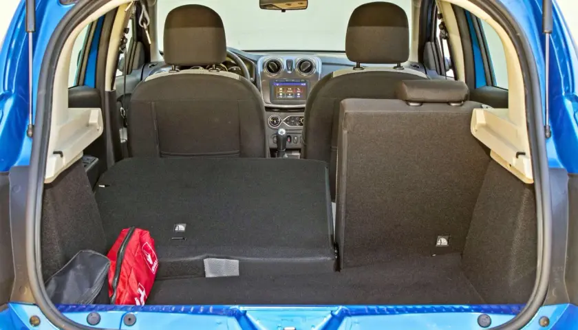 Bagażnik Dacia Sandero, gotowy na podróż. Widoczna apteczka i torba.