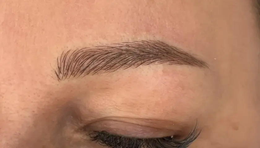 Efekt naturalnych brwi po zabiegu microblading. Delikatne włoski podkreślają kształt oka.