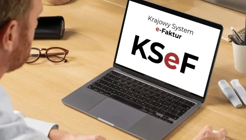 Mężczyzna pracuje przy laptopie z logo KSeF. Ułatwia to księgowanie faktur kosztowych.