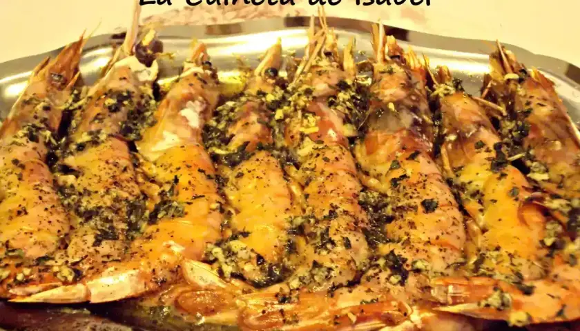 Langostinos al horno, jugosos y dorados, con hierbas y ajo, servidos en una bandeja metálica. ¡Un manjar de La Cuineta de Isabel!