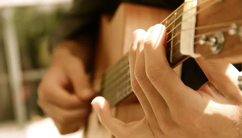 Dłonie grające na gitarze, tworząc melodię, która mogłaby być równie piękna i wzruszająca jak "Lacrimosa".