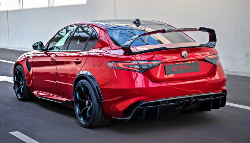 Czerwone Alfa Romeo Giulia GTAm z masywnym spoilerem i dyfuzorem, gotowe do wyścigu.