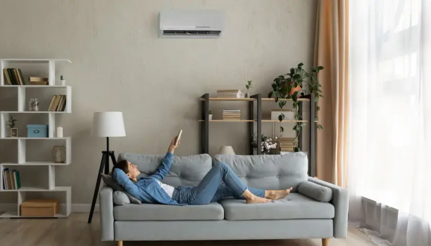 Soggiorno con pareti grigio moderno, divano comodo e aria condizionata. Perfetto per rilassarsi con un libro.