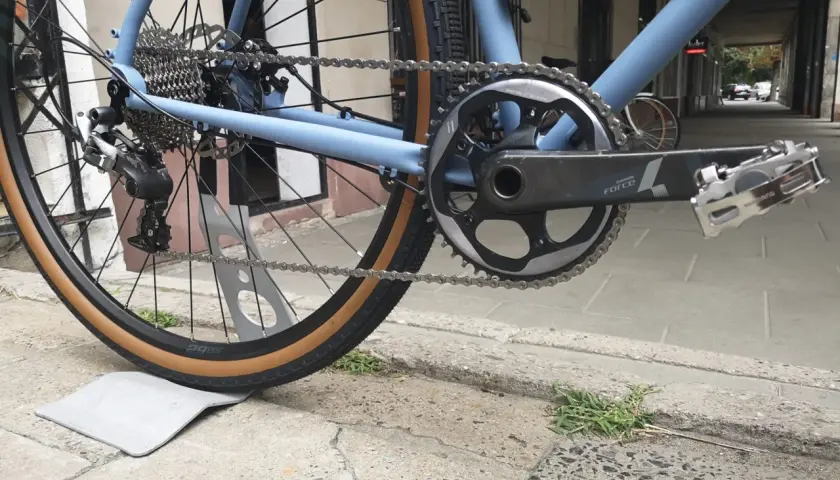 Błękitny rower z napędem Shimano, widok na tylne koło, kasetę i korbę.